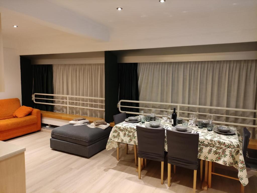 a dining room with a table and a couch at Doss della Pesa Apartment - CIPAT 22114 in Marilleva