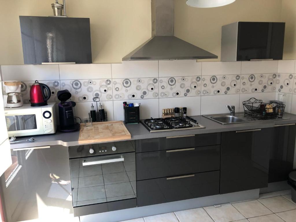 a kitchen with a stove and a microwave at APPARTEMENT CONLEAU VANNES une Chambre WIFI in Vannes