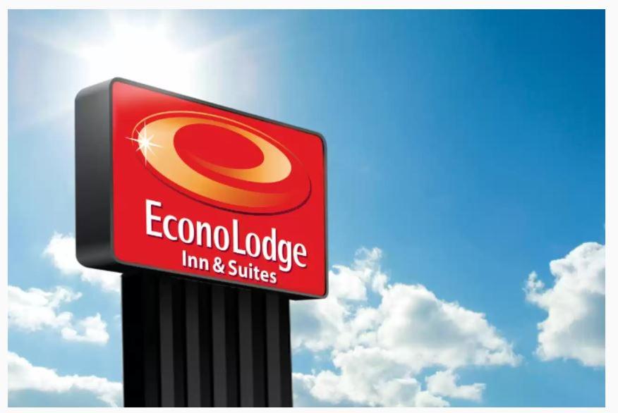 a red and white sign for a corona envelope firm and shuttle at Econo Lodge Inn & Suites in Altus