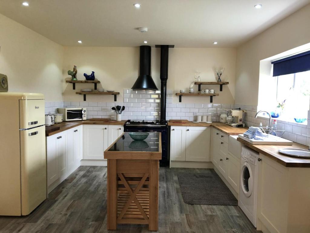 a kitchen with white cabinets and a stove top oven at Entire cosy home from home country retreat in Holyhead