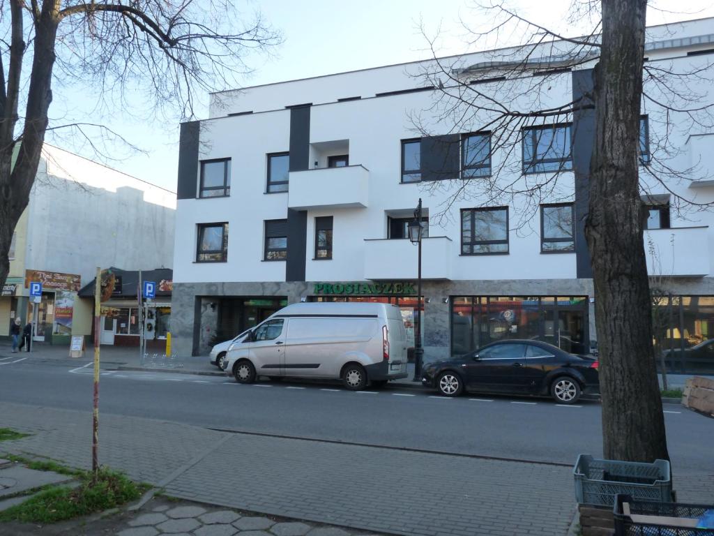 Apartament w centrum Ciechocinka في تشيخوتشينيك: سيارة فان بيضاء متوقفة أمام مبنى