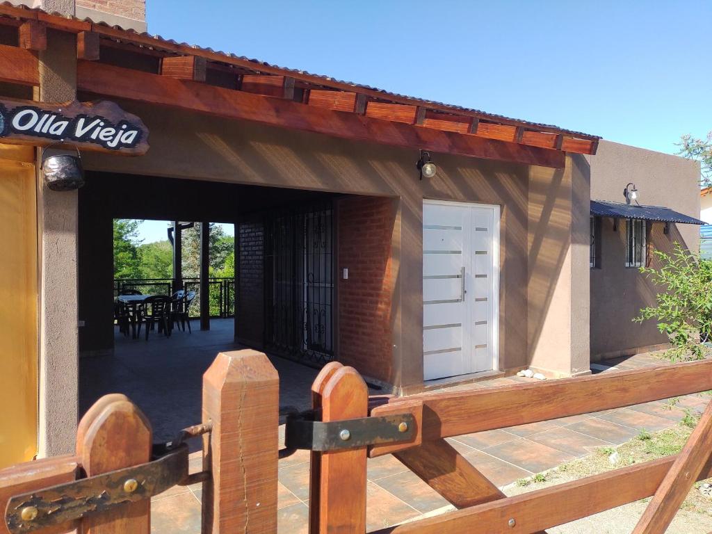 - un bâtiment avec une terrasse en bois et une porte dans l'établissement Cabañas Olla Vieja, à Santa Rosa de Calamuchita