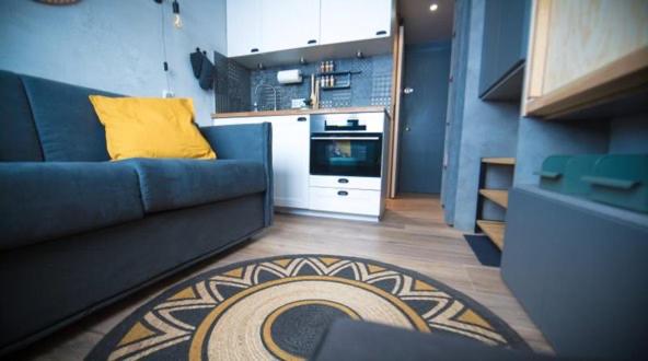sala de estar con sofá azul y almohada amarilla en Cosy - Appartement 2 personnes - Tignes le Lac - 415 - Le Palafour en Tignes