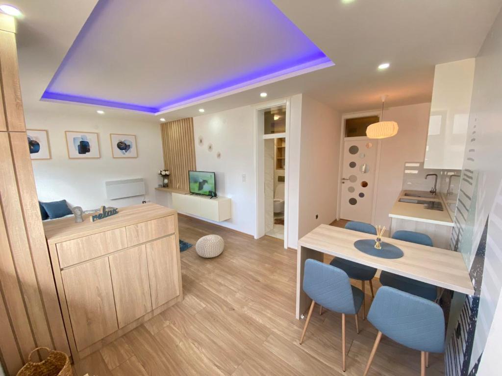 a kitchen with a purple ceiling and blue chairs at Alexandrea Apartments in Pale