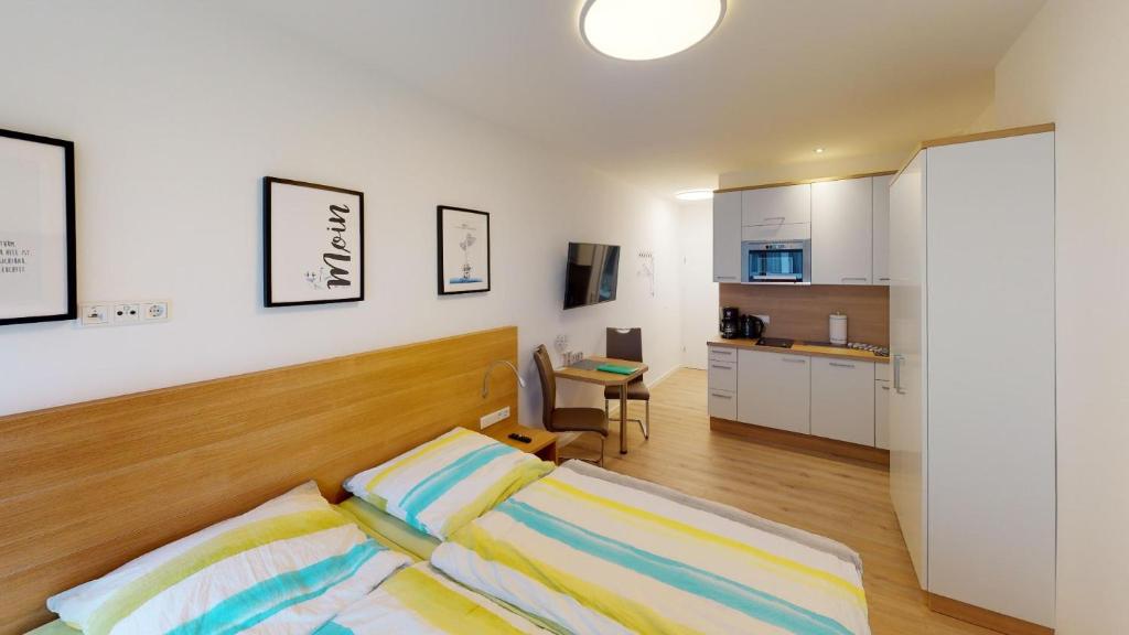 Cet appartement comprend une chambre avec un lit et une cuisine. dans l'établissement Alte Teestube Schmidt 68, à Norderney