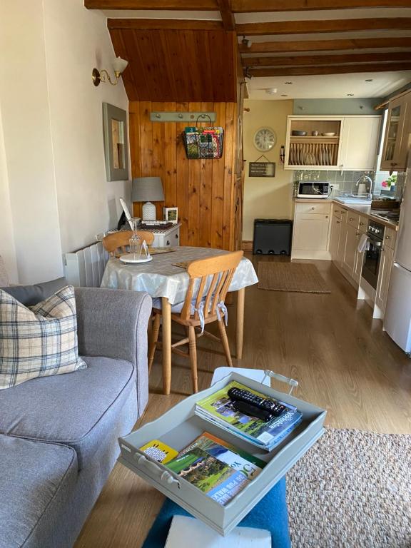 a living room with a couch and a table at Johnnies Cottage a 1 bedroom bolt hole in the heart of Bainbridge, Yorkshire Dales in Leyburn