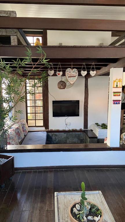 a living room with a couch and a tv at Pousada Cores da Passarela - Sob nova direção in Porto Seguro