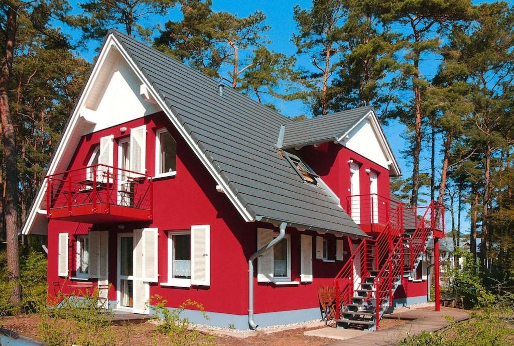 una casa roja y blanca con techo negro en Apartment house, Trassenheide, en Trassenheide
