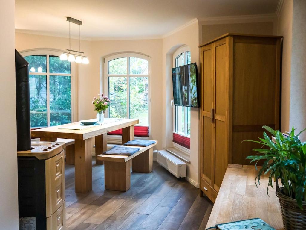 a kitchen with a wooden table and some windows at Modern Bungalow in Tessmannsdorf on Coastal Forest in Teßmannsdorf