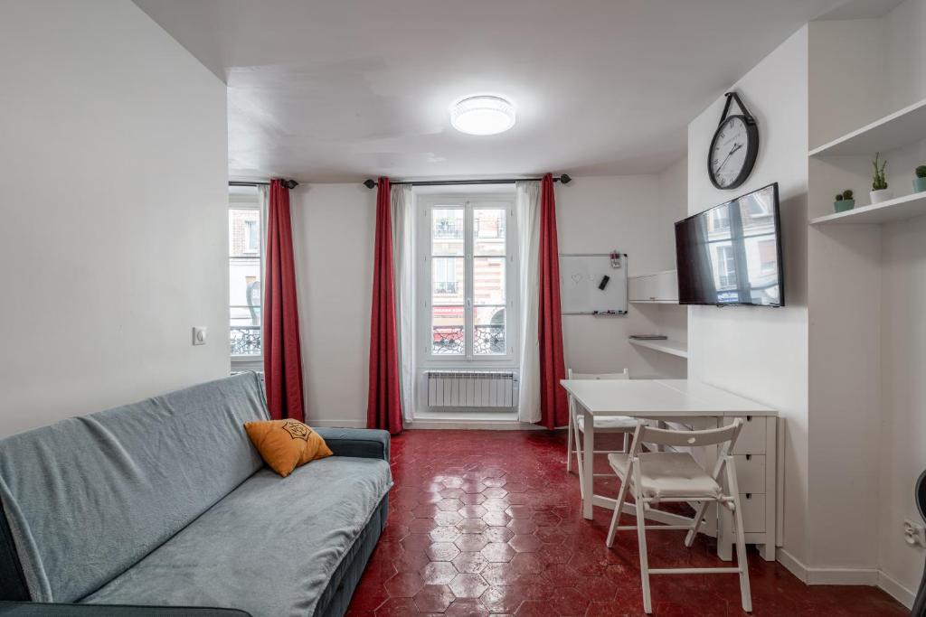 een woonkamer met een bank en een tafel bij Logement entier à Paris in Parijs