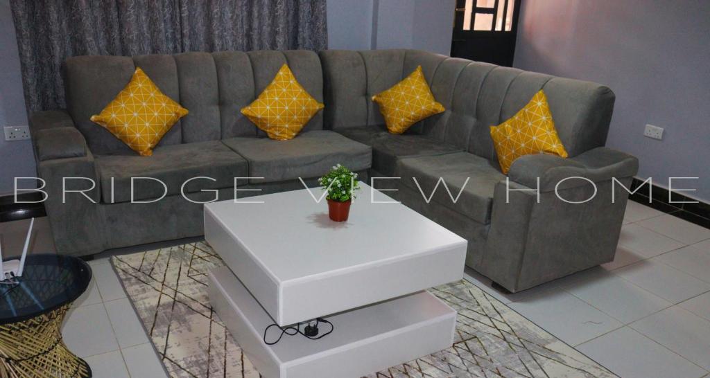 ein Wohnzimmer mit einem Sofa und einem weißen Tisch in der Unterkunft Maggie Home Stay Naivasha - Bridge View Aprt in Naivasha