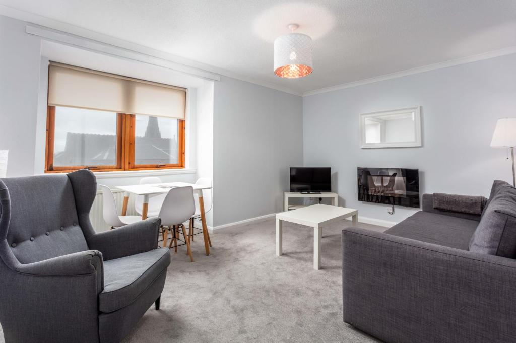 een woonkamer met een bank en een tafel bij Prestwick Central - Donnini Apartments in Prestwick