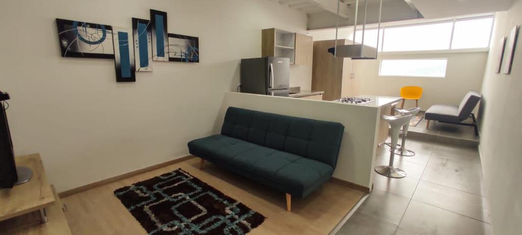 sala de estar con sofá verde y mesa en San Martin- Moderno y confortable apartaestudio sector rosales, en Manizales