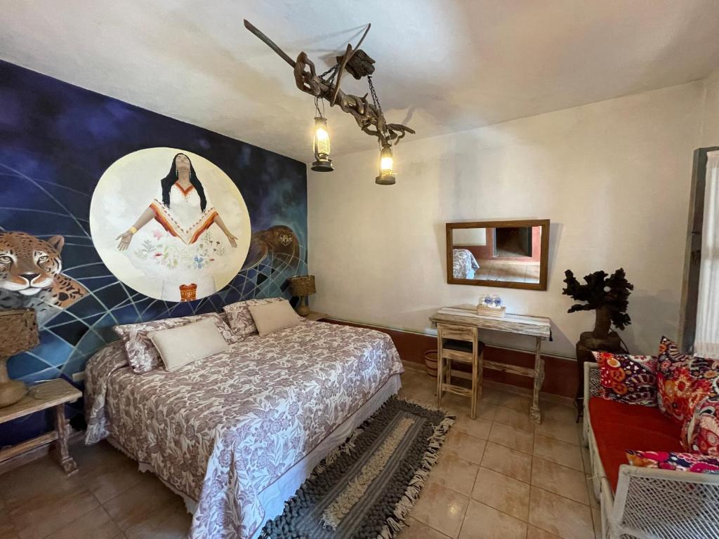 1 dormitorio con 1 cama y una pintura en la pared en La Casona Azul Boutique Hotel, en Malinalco