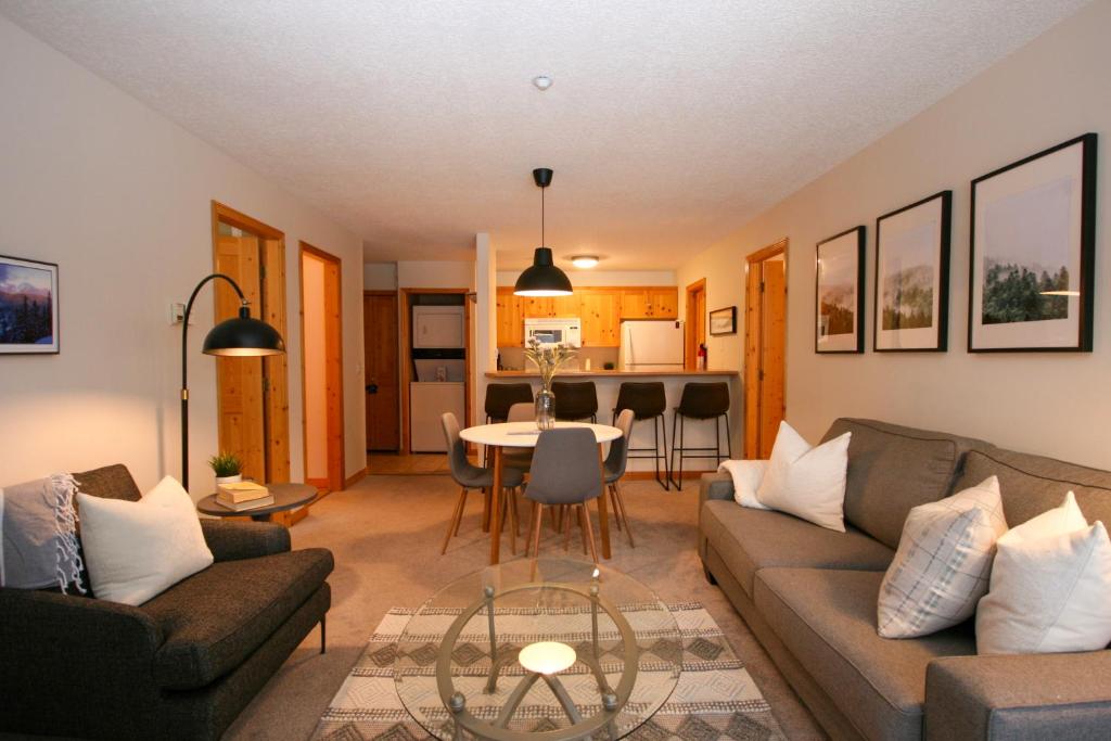 uma sala de estar com um sofá e uma mesa em CRYSTAL FOREST 2BR Ski In Ski Out with PRIVATE Hot Tub em Sun Peaks