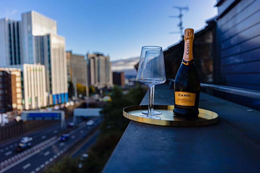 a bottle of wine and a wine glass on a ledge at The Skyline Suite - *Private Balcony* *Views* in Glasgow