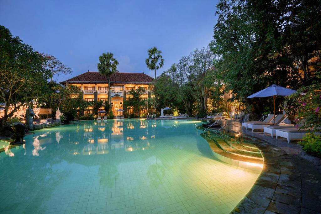 a swimming pool at a resort at night at Hotel Kumala Pantai in Legian