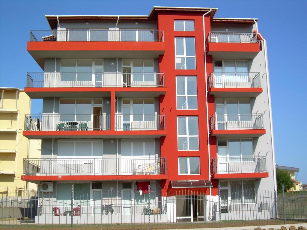 プリモルスコにあるStudio Stella Primorskoの赤いアパートメントで、白いバルコニーが付いています。