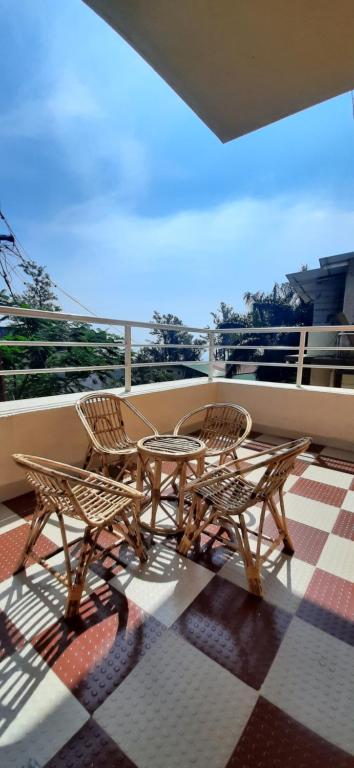 a patio with two chairs and a table on a balcony at Trimurti Holiday Home in Panchgani