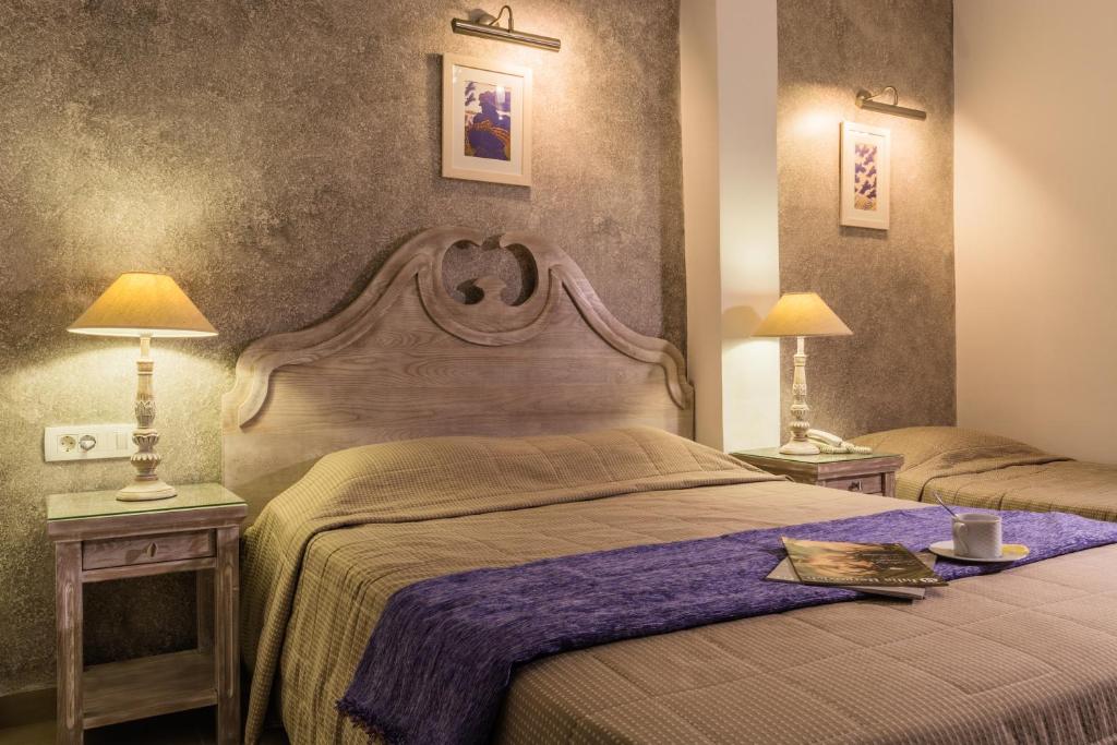 1 dormitorio con 1 cama grande y 2 mesas con lámparas en Hotel Sunrise, en Fira
