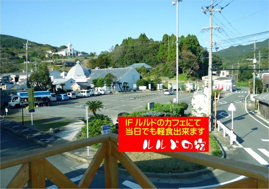 un letrero rojo en un balcón con una calle en Amakusa - House / Vacation STAY 5321, en Amakusa