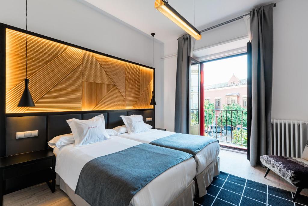 a bedroom with a large bed and a large window at Hotel Sevilla in Seville