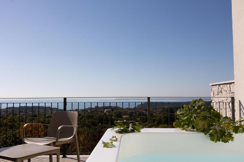 a bath tub on a balcony with a view of the ocean at Encanto Agriturismo & Private SPA in Visogliano