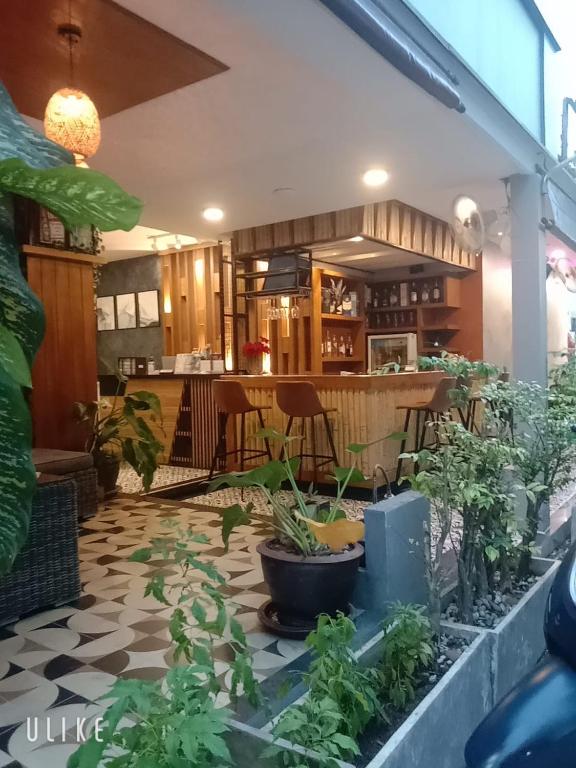 a patio with plants on the floor of a restaurant at The Mantra Hotel Kata Noi in Kata Beach