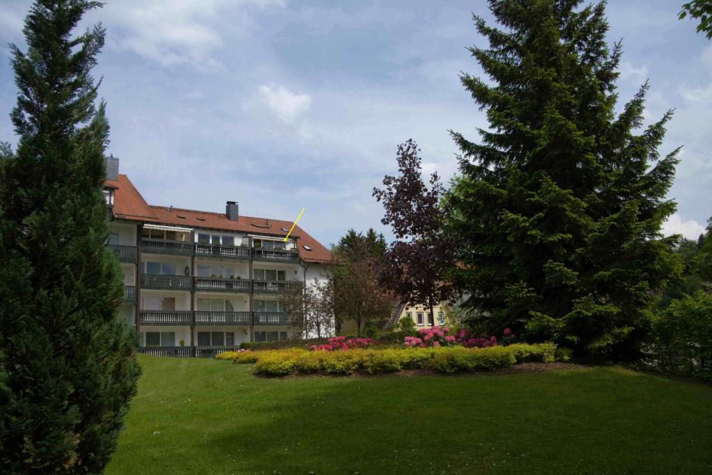 ein großes Gebäude mit Bäumen und Blumen im Hof in der Unterkunft Maisonette Apartment am Kurpark in Braunlage