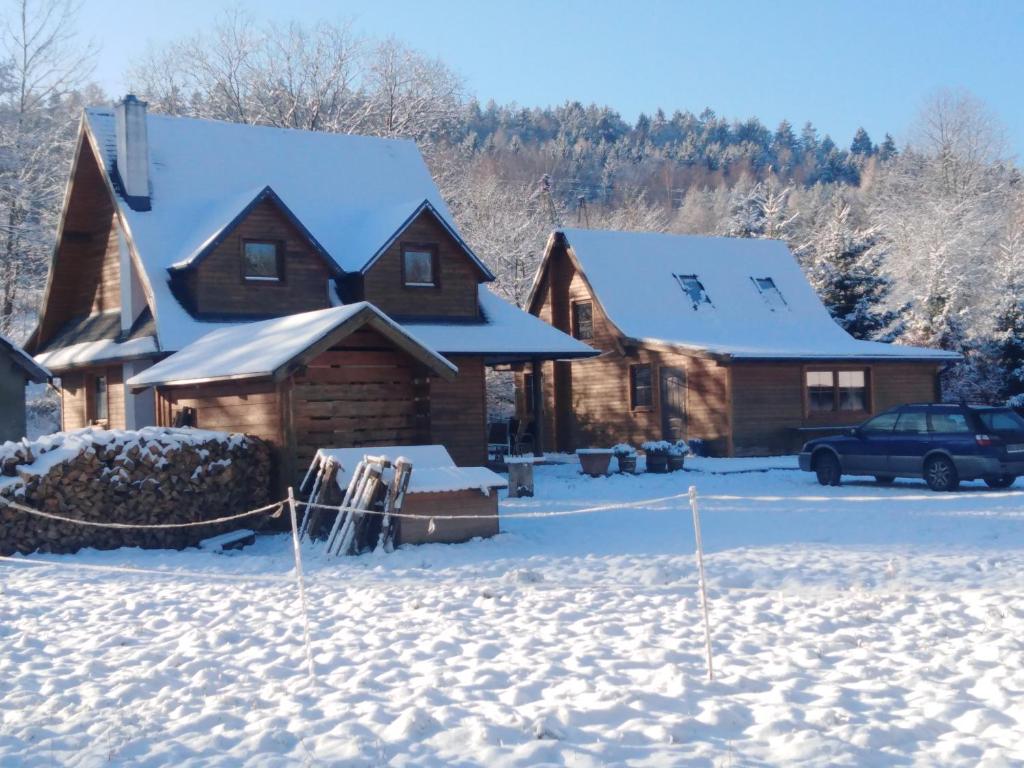 una cabaña de madera en la nieve con esquís en el patio en Rancho Vaquera, en Polanica-Zdrój