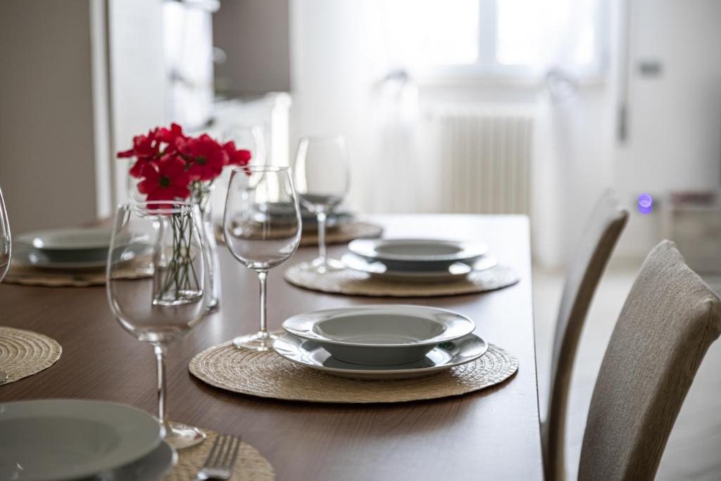 - une table en bois avec des assiettes et des verres à vin dans l'établissement Minerva Holiday Home, à Manerba del Garda