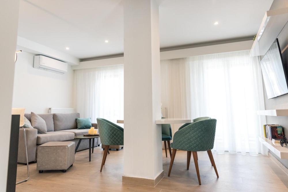 a living room with a couch and a table and chairs at Amelia Luxury Living in Volos
