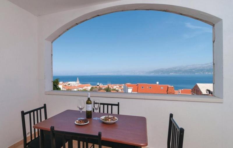 a table with a bottle of wine and a window at apartmani Tanja in Postira