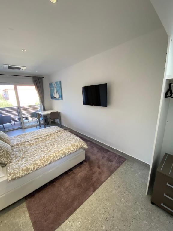 Televízia a/alebo spoločenská miestnosť v ubytovaní Apartmani Kumenat