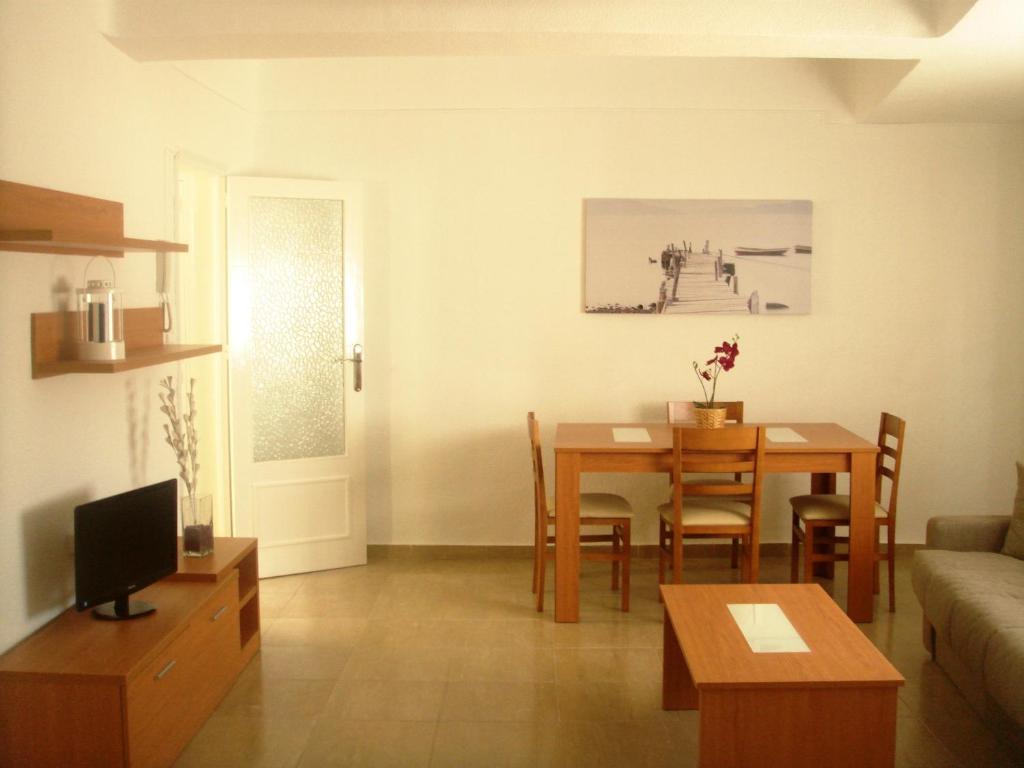 a living room with a table and a dining room at Apartamentos Margoysa I in Los Alcázares