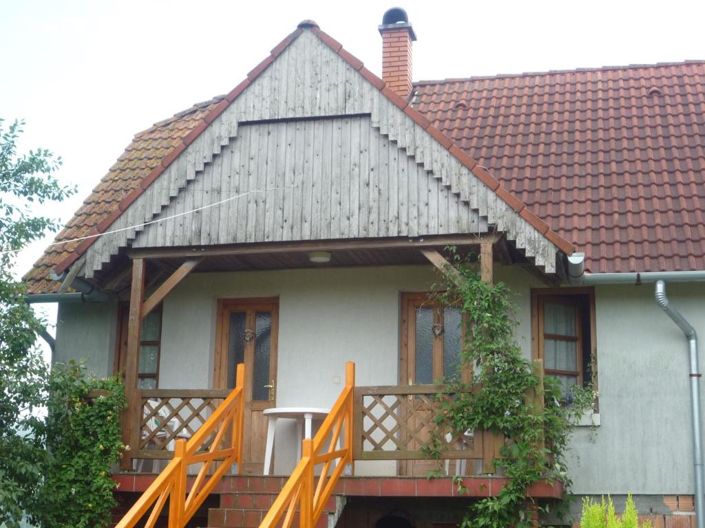 a small house with a porch and a brown roof at Hoffmann Vendégház in Nagyrákos