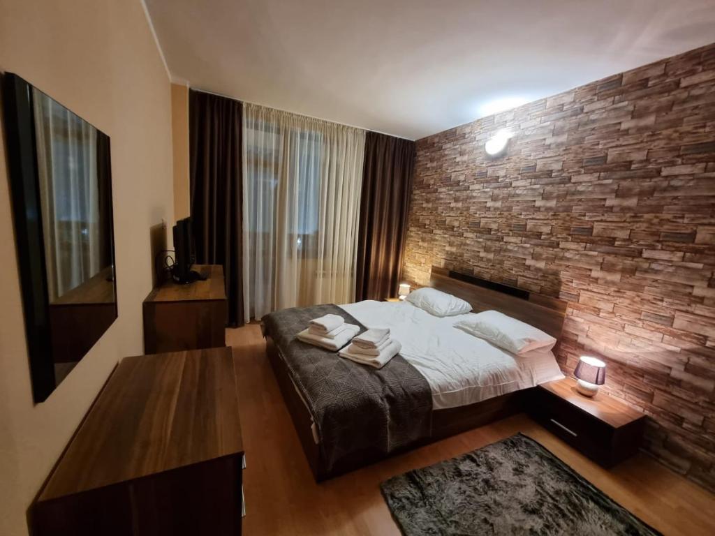 a bedroom with a brick wall and a bed at Borovets Sequoia2 luxury Apartment in Borovets