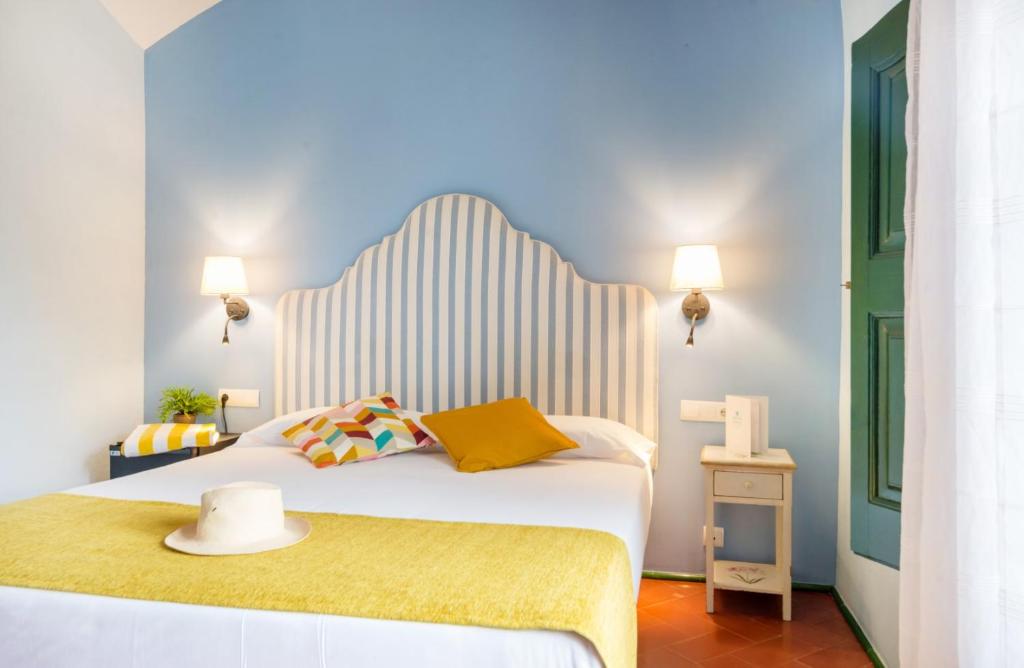 a bedroom with a large white bed with a yellow blanket at Mas Ses Vinyes - Adults Only in Begur