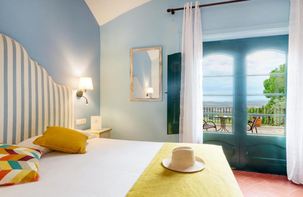 a bedroom with a bed with a view of a balcony at Mas Ses Vinyes - Adults Only in Begur