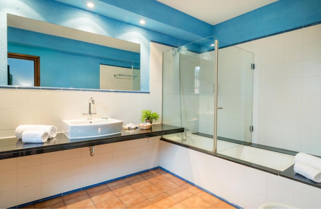 a bathroom with a sink and a glass shower at Mas Ses Vinyes - Adults Only in Begur