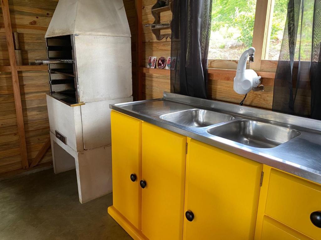 グラマドにあるMorada Pé da Montanhaのシンクと冷蔵庫付きのキッチン