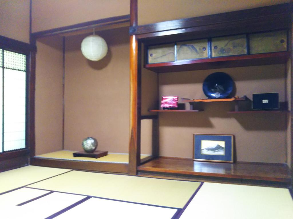 una camera con una parete e uno specchio di ゲストハウス「古民家の宿梨本軒」 a Takayama
