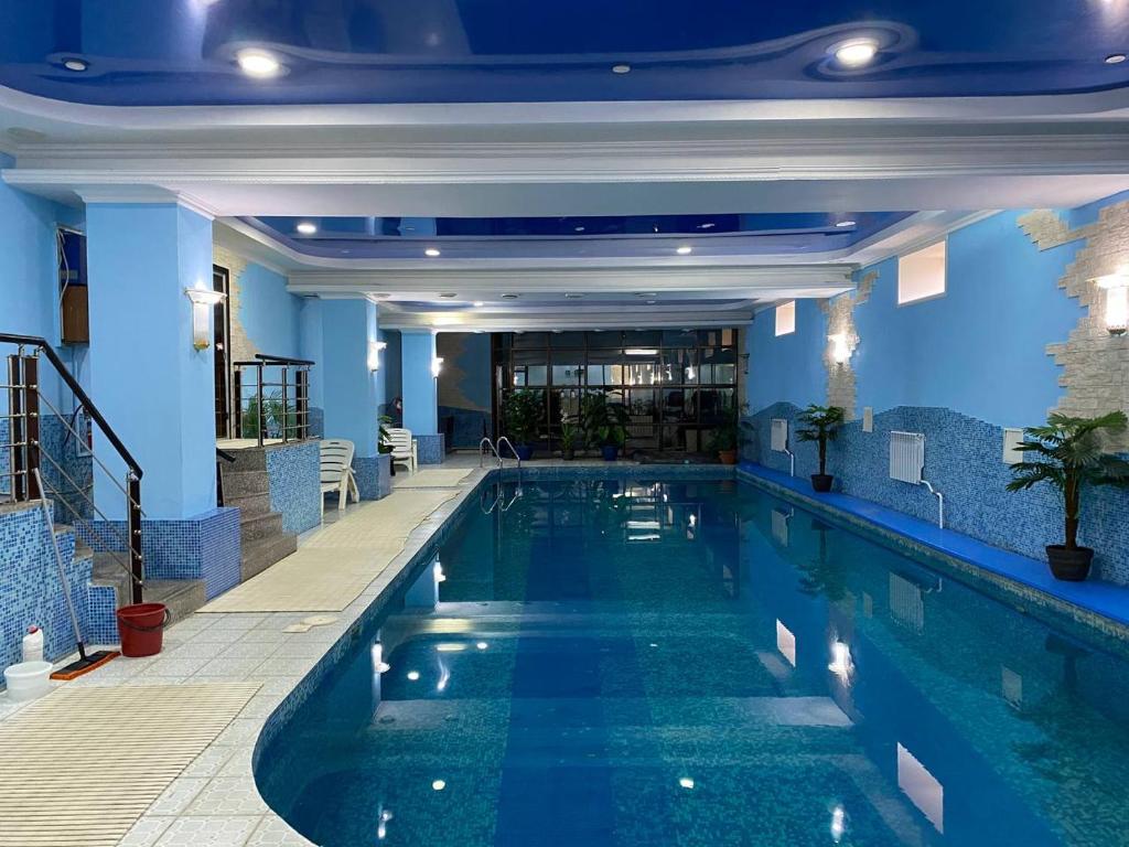 a swimming pool in a hotel with blue walls at Deluxe SPA-Hotel in Ustʼ-Kamenogorsk