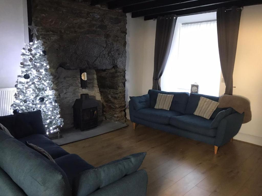 a living room with a christmas tree and a blue couch at The Anchorage Snowdonia in Blaenau-Ffestiniog