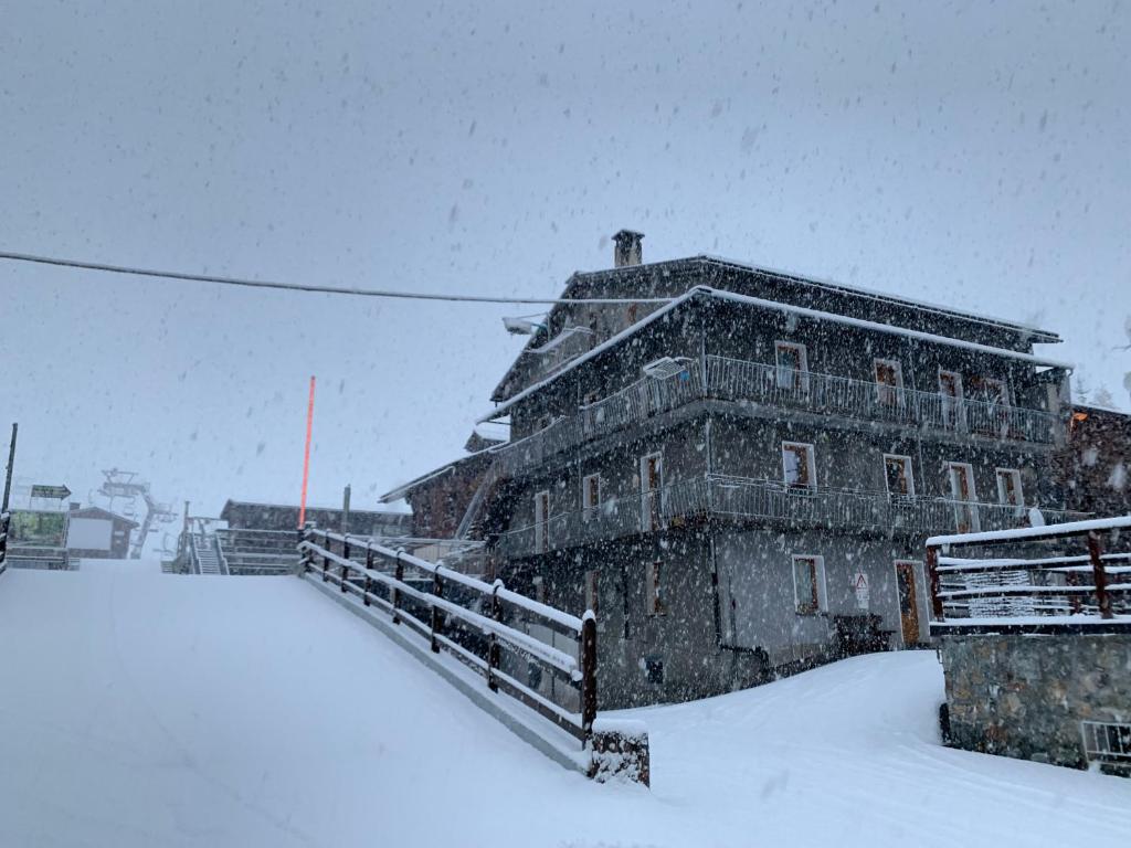 um grande edifício coberto de neve na frente em Pedrin's House em Livigno