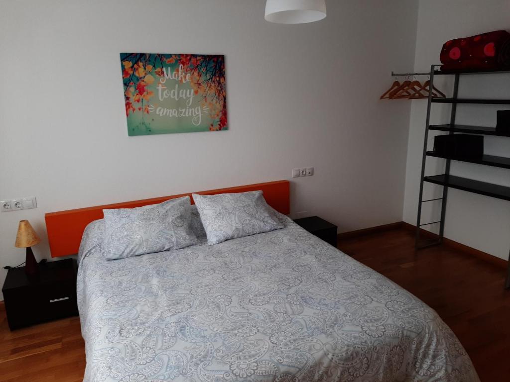 1 dormitorio con 1 cama y una foto en la pared en Apartamento con jardin privado y piscina, en Cirueña