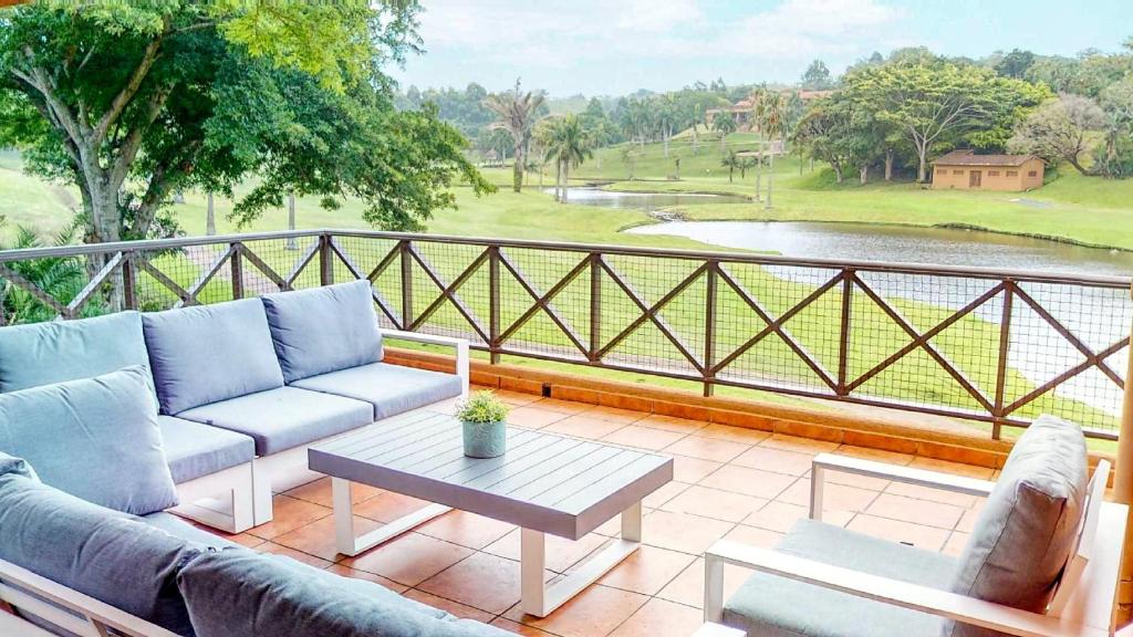 a patio with couches and a table on a balcony at San Lameer Supreme by Top Destination Rentals in Southbroom