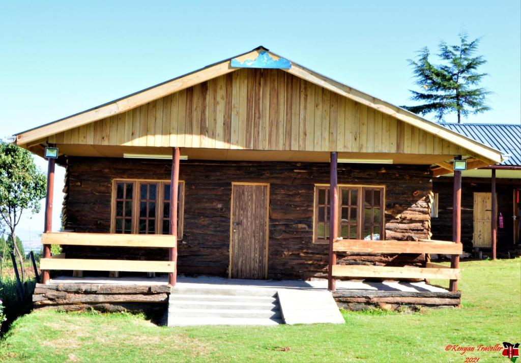 Cabaña de madera con porche y puerta en The Wonky House, en Timau