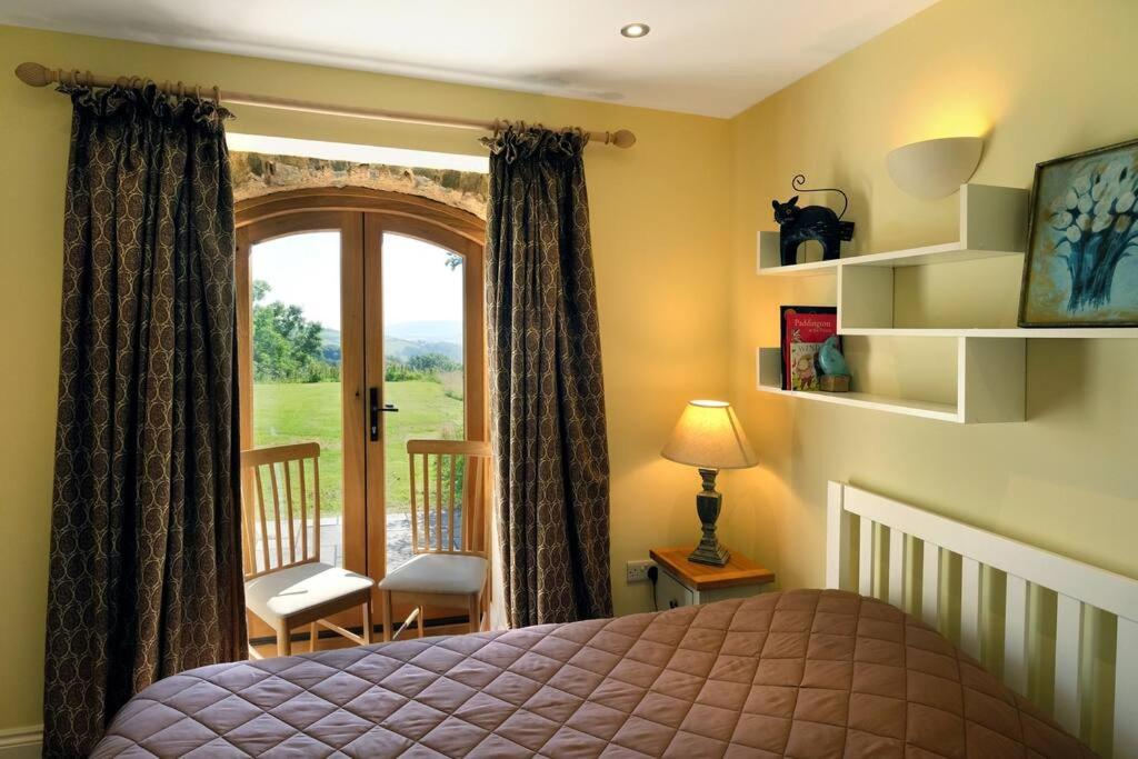 1 dormitorio con 1 cama y puerta con ventana en Paradise position on Exmoor National Park, en Minehead