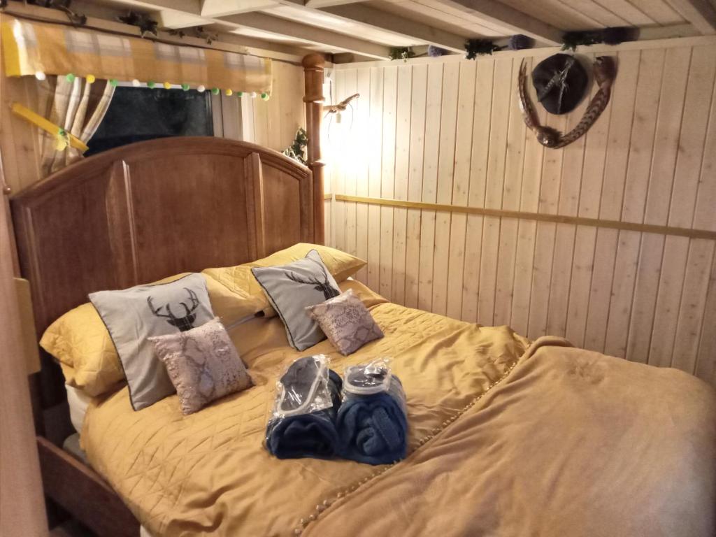a bed with two bags on top of it at Glamping Malvern shepherd hut in Malvern Link